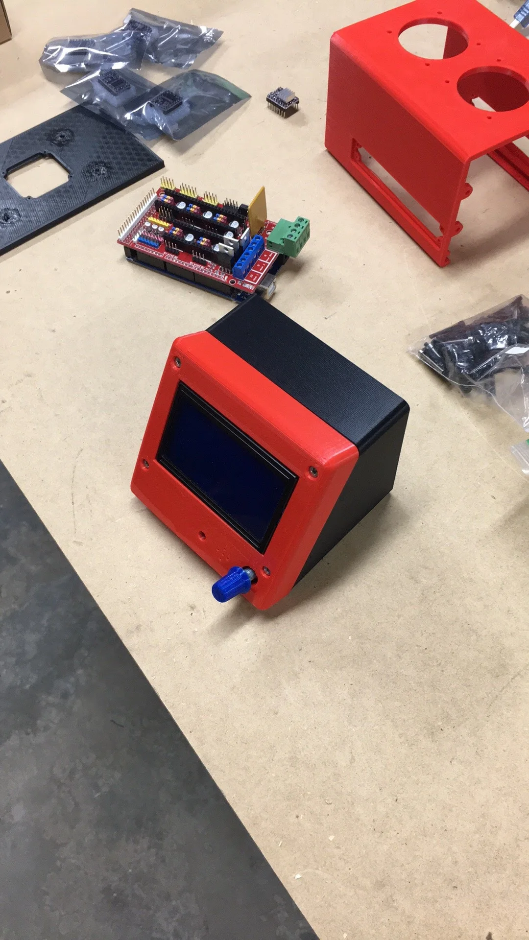 Custom red and black 3D printed controller enclosure beside its electronics