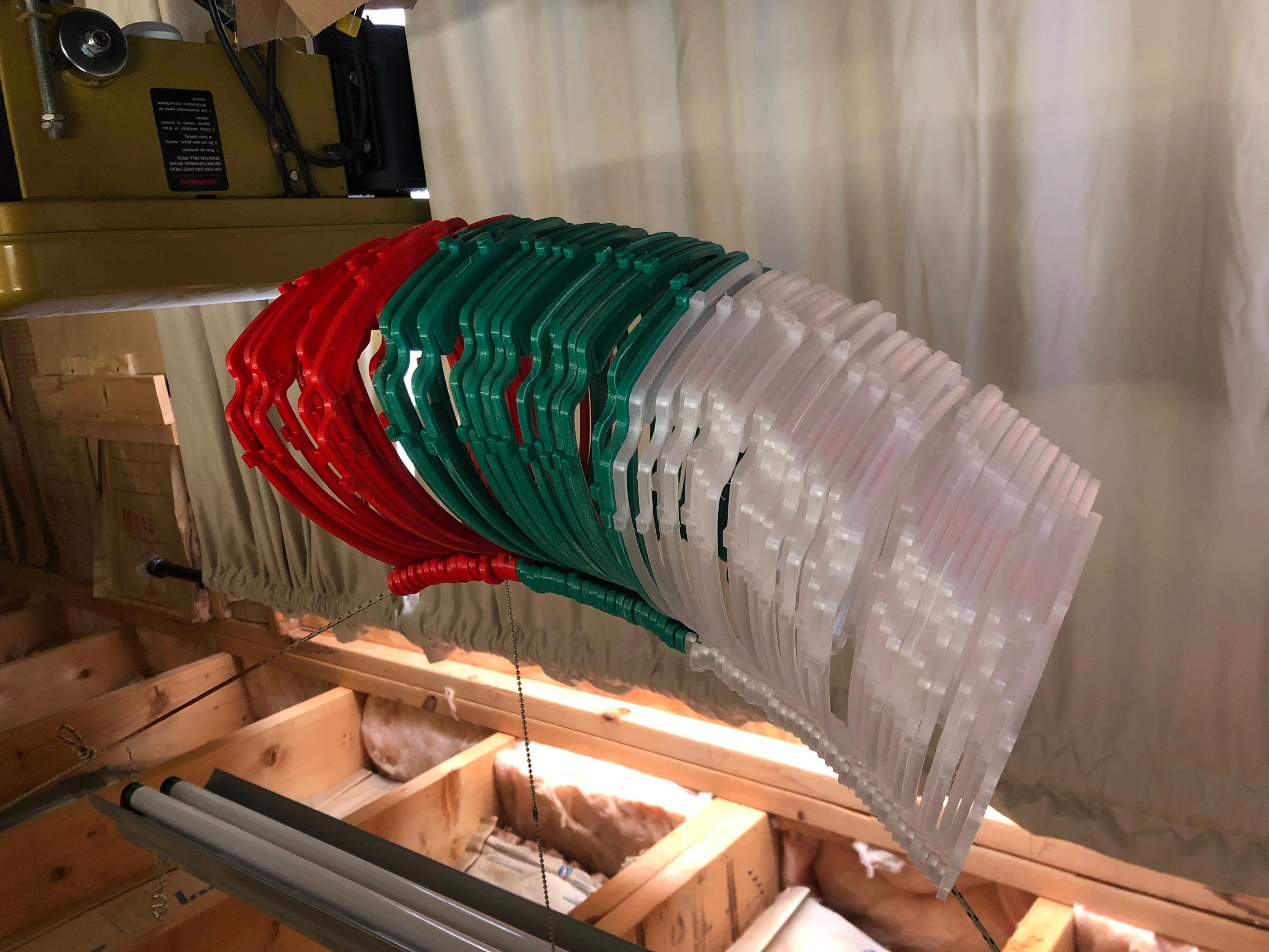 A large completed batch of red, green, and clear face-shield frames